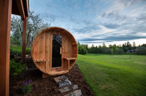 Round wooden sauna outdoor in a yard.
