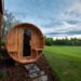 Round wooden sauna outdoor in a yard.